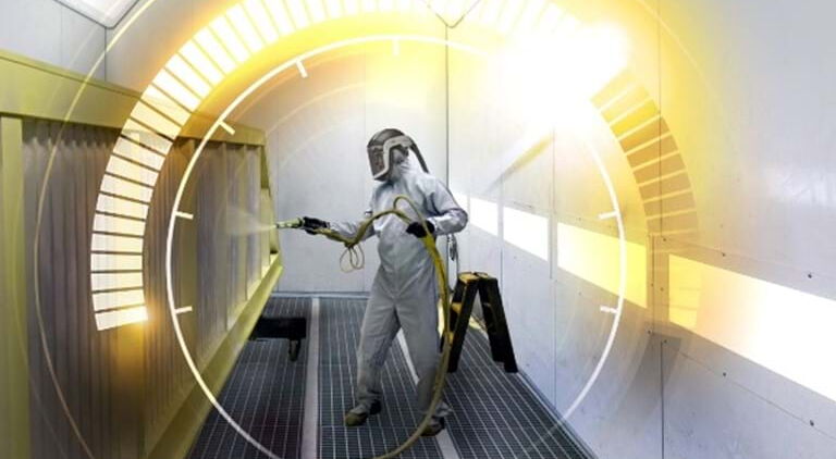 Lackierer im Schutzanzug mit Sprühpistole lackiert eine Objekt